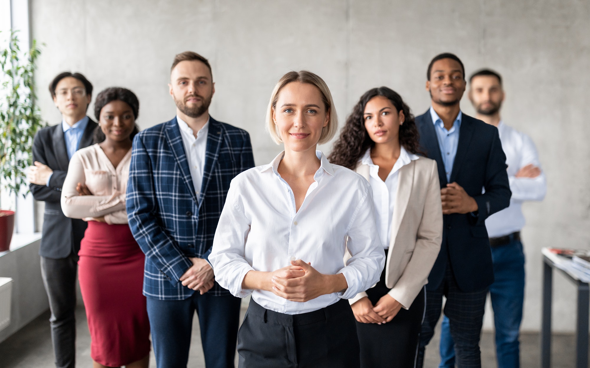 successful-businesswoman-standing-in-front-of-business-team-in-office.jpg